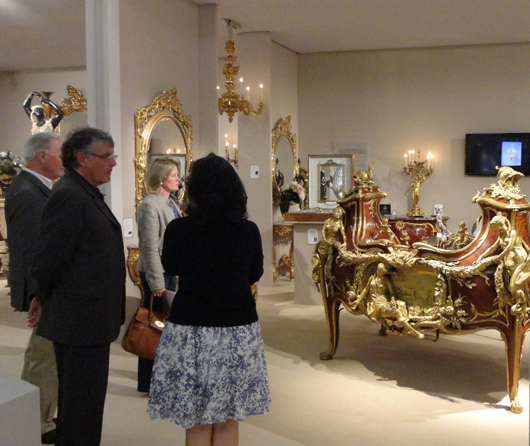 Visitors to London's Masterpiece fair admire a rococo Revival bureau by 19th century French ébéniste François Linke on the stand of London dealer Adrian Alan. Photo Auction Central News.